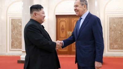 朝鲜最高领导人金正恩（左）和俄罗斯外交部长拉夫罗夫，周四在朝鲜平壤举行会议时握手合影留念。（图取自俄罗斯外交部/路透社）