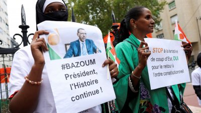 此前8月在法国巴黎，示威者在尼日尔大使馆外举著标语牌和被罢黜的总统巴祖姆肖像，反对军方政变及支持巴祖姆。（路透社档案照）