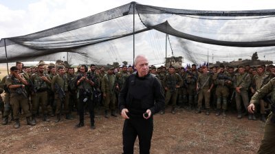 以色列国防部长加兰特（中）周四到以色列与加沙地带边境附近视察，向驻扎当地的士兵发表讲话。（图取自路透社）