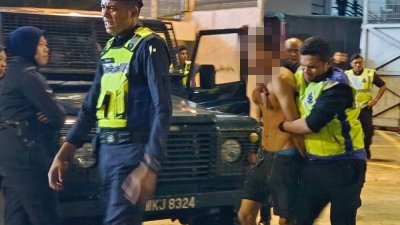 一名赤裸上身的男子被数名警员制伏在地。（视频截图）