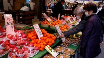 图为今年3月的日本东京，市民在一个市场购买水果等食材。（图取自路透社）