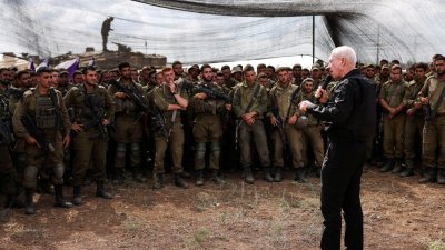 以色列国防部长加兰特于上周四，在以色列南部靠近以色列与加沙地带边境的一处场地会见士兵。（图取自路透社）