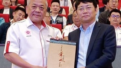 丹斯里吴添泉（左）赠送华总出版的《马来西亚华人博物馆史料汇编》于中国经济学家兼金融研究院院长管清友。