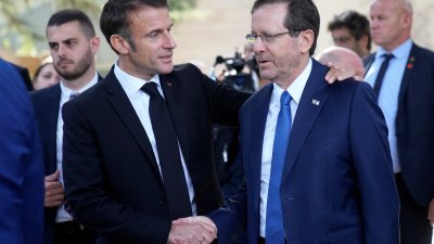 周二在耶路撒冷举行会谈后，法国总统马克龙（左）与以色列总统赫尔佐格握手。（图取自路透社）