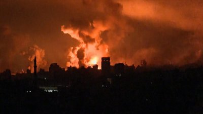 以色列当地时间周五晚扩大对加沙地带的空中和地面攻击，画面可见当晚遭到轰炸后的加沙城。（图取自法新社）
