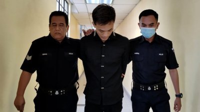 潘轩耀（译音）在庭警的带领下前往处理保释程序。