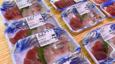 8月9日，日本福岛县相马市一家超市里，陈列著一包包的生鱼片。（图取自路透社）