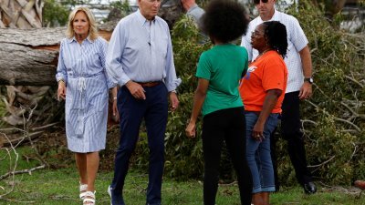 美国总统拜登（左2）和夫人吉尔赴佛州探视飓风灾情，他们在学校和撤离的居民见面。（图取自路透社）