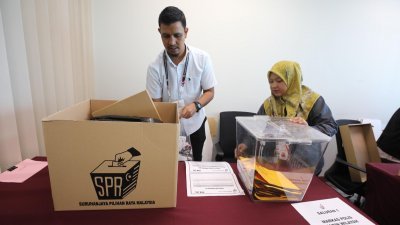 选举局官员检查补选票箱及相关用具。