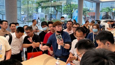 在中国广东省深圳市华为旗舰店，一名工作人员8月30日向顾客介绍新款华为 Mate 60智能手机。（图取自路透社）