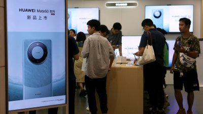 图为周四在中国北京商场，一家打著华为最新手机Mate 60广告的华为旗舰店。（图取自路透社）