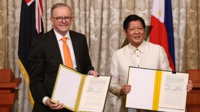 澳洲总理阿尔巴尼斯（左）和菲律宾总统小马科斯，周五在菲律宾马尼拉举行双边会谈，并在签署谅解备忘录后合影留念。（图取自路透社）