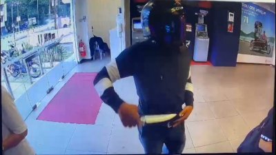 匪徒于今年5月14日走进安德申路某间银行提款机部，亮刀抢劫2名正在提款的妇女。（视频截图）