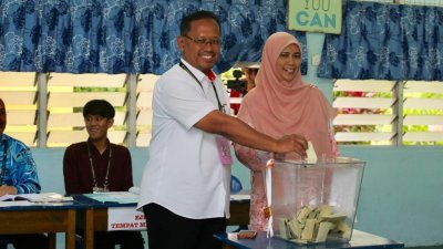 苏海占（左）和妻子在投票中心，为自己投下一票。