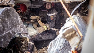 救援人员在倒塌的建筑物瓦砾下搜索。（图取自法新社）