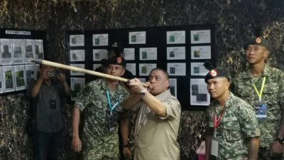 沙拉尼（左2）为Citra Nusa@ Muzium Matang活动主持开幕后，巡视展览区时，在陆军参展区举吹箭筒试吹。