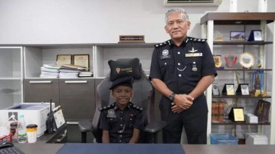 华都牙也警区主任莫哈末罗伊助理总监在今年6月6日为男童圆梦，让男童成为一日警察，并让男童穿上警察制服。（图取自华都牙也警区面子书）