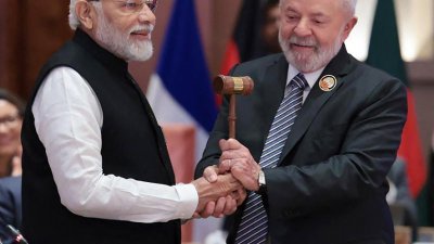 印度总理莫迪（左）周日在印度新德里举行的20国集团（G20）峰会闭幕式上，将象征G20主席国职位的礼仪木槌移交给巴西总统卢拉，正式完成G20主席国交接仪式。（图取自法新社）