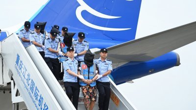  一架中国民航包机周一下午在重庆江北国际机场降落，18名电信网络诈骗嫌犯被重庆市警方从寮国顺利押解回中国。（图取自中新社）