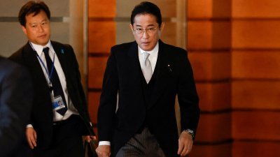 日本首相岸田文雄（右）周三离开官邸，与内阁部长一起到皇居参加认证仪式。（图取自路透社）