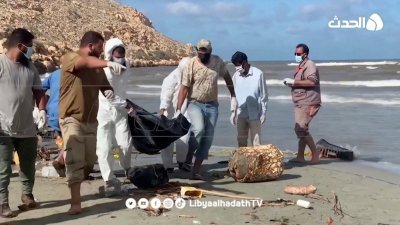志愿者周四在利比亚遭受洪水重创的德尔纳，从海中打捞出一具遇难者遗体。（图取自利比亚Al-Hadath电视台/路透社）