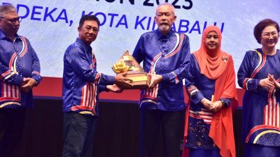 副首长兼地政及房屋部长拿督佐津昆沙南（左2）代表首长哈芝芝，移交纪念品予出席2023年州级马来西亚日庆典的沙巴州元首敦朱哈玛希鲁丁。