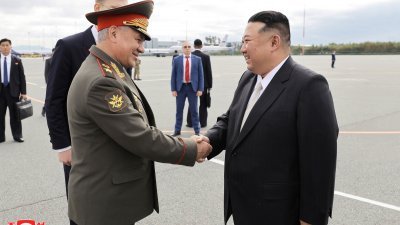 俄罗斯国防部长绍伊古（左）周六在俄罗斯符拉迪沃斯托克，欢迎前来访问的朝鲜最高领导人金正恩。（图取自朝中社/路透社）