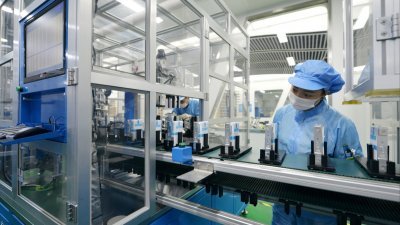 2018年8月28日，中国浙江省湖州一家工厂，一名工人正在注视著电动汽车锂离子电池生产线。（图取自路透社）