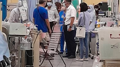黄汉伟（右2）向槟城中央医院的医护人员，了解2名新加坡游客的伤势。