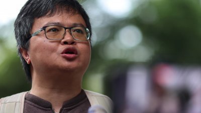 泰国著名活动人士、前人权律师阿农，周二在曼谷刑事法庭对他涉嫌冒犯王室的案件做出判决前，向媒体发表讲话。（图取自路透社）