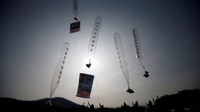 2014年1月15日，居住在韩国的脱北者在北部京畿道坡州市分隔两国的非军事区附近，释放装有一美元纸币、收音机、光碟和谴责朝鲜政权传单的气球。（路透社档案照）