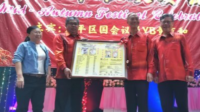 北霹雳中华总商会署理会长杜保强（左2起），赠送纪念品予受封拿督的洪宝德。