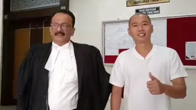 律师峇拉柯斯南（左）陪同下，陈毕果（译音）面带微笑比赞离开法庭。