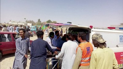 巴基斯坦西南部的俾路支省，周五发生自杀式炸弹袭击事件，一名伤者被转移到救护车上，准备送往医院治疗。（图取自路透社）