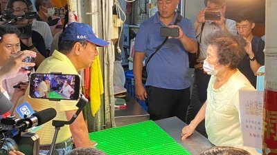台湾鸿海创办人郭台铭（戴帽者）周二参访东门市场，并与摊商互动。他接受媒体访问时表示，副手人选有4条件，其中一定是女性。（图取自中央社）