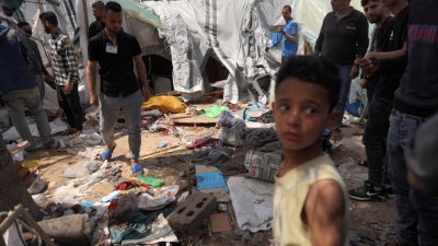 加沙地带中部阿克萨医院前的无家可归者临时营地遭到以色列轰炸，巴勒斯坦人事后检查损坏情况。（图取自法新社）