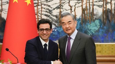 法国外交部长塞茹尔内（左）周一在北京钓鱼台国宾馆与中国外长王毅会面。（图取自法新社）