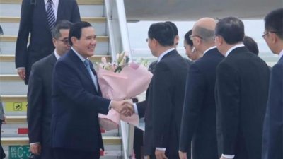台湾前总统马英九抵达深圳宝安机场，与接机的中国国台办副主任潘贤掌握手问候。（图取自网络）