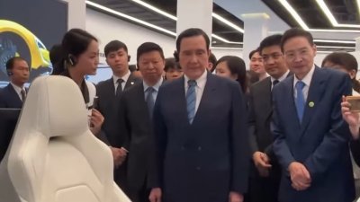 台湾前总统马英九（中）周二到广东省深圳市的比亚迪总部“六角大楼”参观，听讲解员介绍产品和技术。（视频截图）