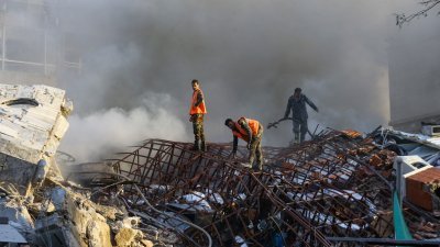 在叙利亚首都大马士革，紧急救援人员周一在遭遇袭击的伊朗大使馆旁的一栋建筑现场扑灭大火。（图取自法新社）