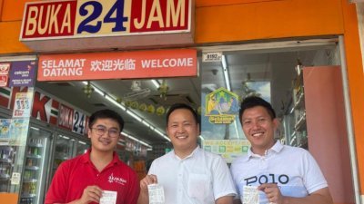 张健仁的特别助理苏天仁（左起）、江峰年及沈杰龙在以消费方式支持KK 便利店后，在便利店门口一同展示收据并合影留念。