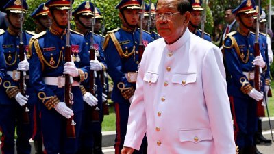 接任柬埔寨参议院议长的洪森，在周三参议院会议结束后，检阅仪仗队。（图取自法新社）