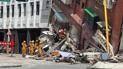 花莲市的天王星大楼倾斜，目前仍有一人失联，消防人员编组带器具入内搜救。（图取自中央社）