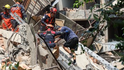 新北市中和区一处建物后栋仓库因地震倒塌，受困者在消防局搜救人员帮助下顺利脱困，缓步爬下楼梯。（图取自中央社）