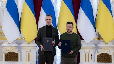 乌克兰总统泽连斯基（右）与芬兰总统斯图布手持两人签署的安全合作协议。（图取自乌克兰总统府新闻处/法新社）