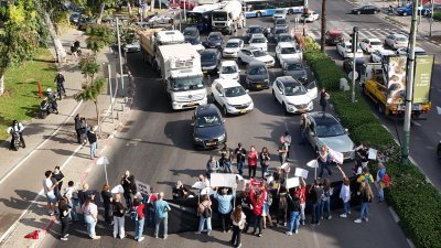 以色列人质亲属和支持者周四在特拉维夫示威期间封锁了道路，要求内塔尼亚胡政府尽快和哈马斯达成协议，换取人质尽早回家。（图取自法新社）