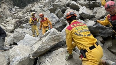救援人员周五在花莲县太鲁阁砂卡礑步道的石堆上，搜寻失踪者。（图取自台湾中央社/搜救人员提供）
