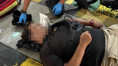 医护人员对倒卧在关卡摩哆车道的男子进行紧急抢救，惟最终证实不治身亡。（图由警方提供）