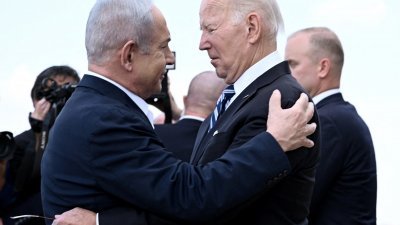 美国总统拜登（右）去年10月18日到访特拉维夫，与迎接他的以色列总理内塔尼亚胡拥抱。（图取自法新社）