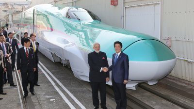 印度总理莫迪（右二）2016年11月12日和时任日本首相的安倍晋三（右），到日本兵库县神户市的子弹列车制造工厂视察，两人在新干线列车前握手。（图取自日本时事通信社/法新社）